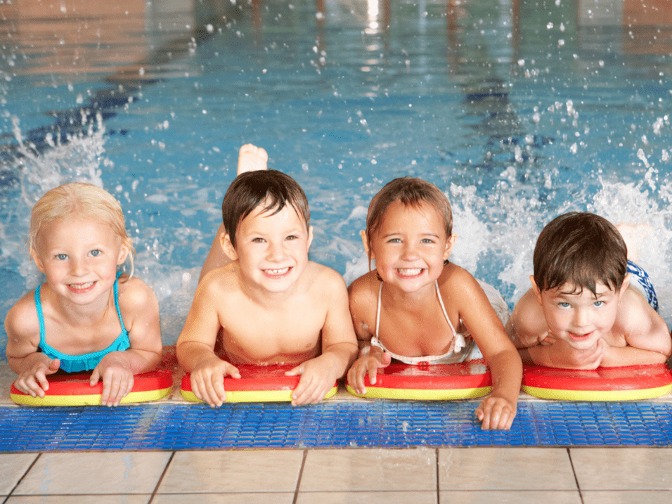 Jungen und Mädchen beim Kinderschwimmen Fünf Jungen und Mädchen, die schwimmen lernen
