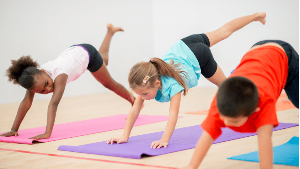 Drei Kinder, die Yoga&uuml;bung auf Gymnastikmatten machen