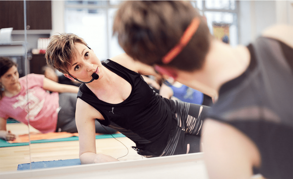 Trainerin zeigt Rückenübung im Präventionskurs für Rückentraining im Sportverein Köln-Ehrenfeld