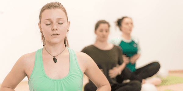 Frauen praktizieren sanftes Hatha-Yoga im Präventionskurs beim Sportverein Köln Ehrenfeld